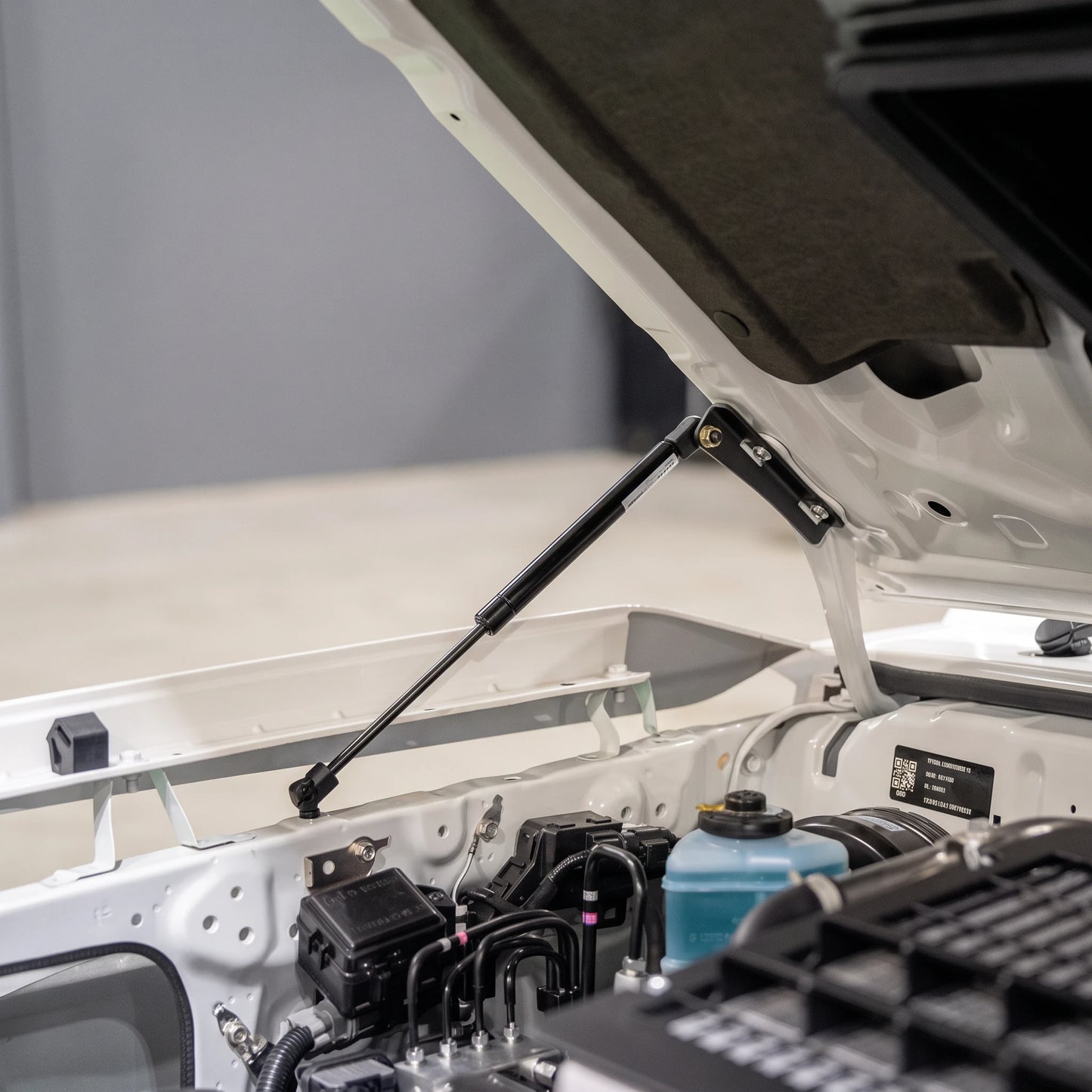70 Series Land Cruiser bonnet held open by the fitted gas strut kit, viewed from the engine bay