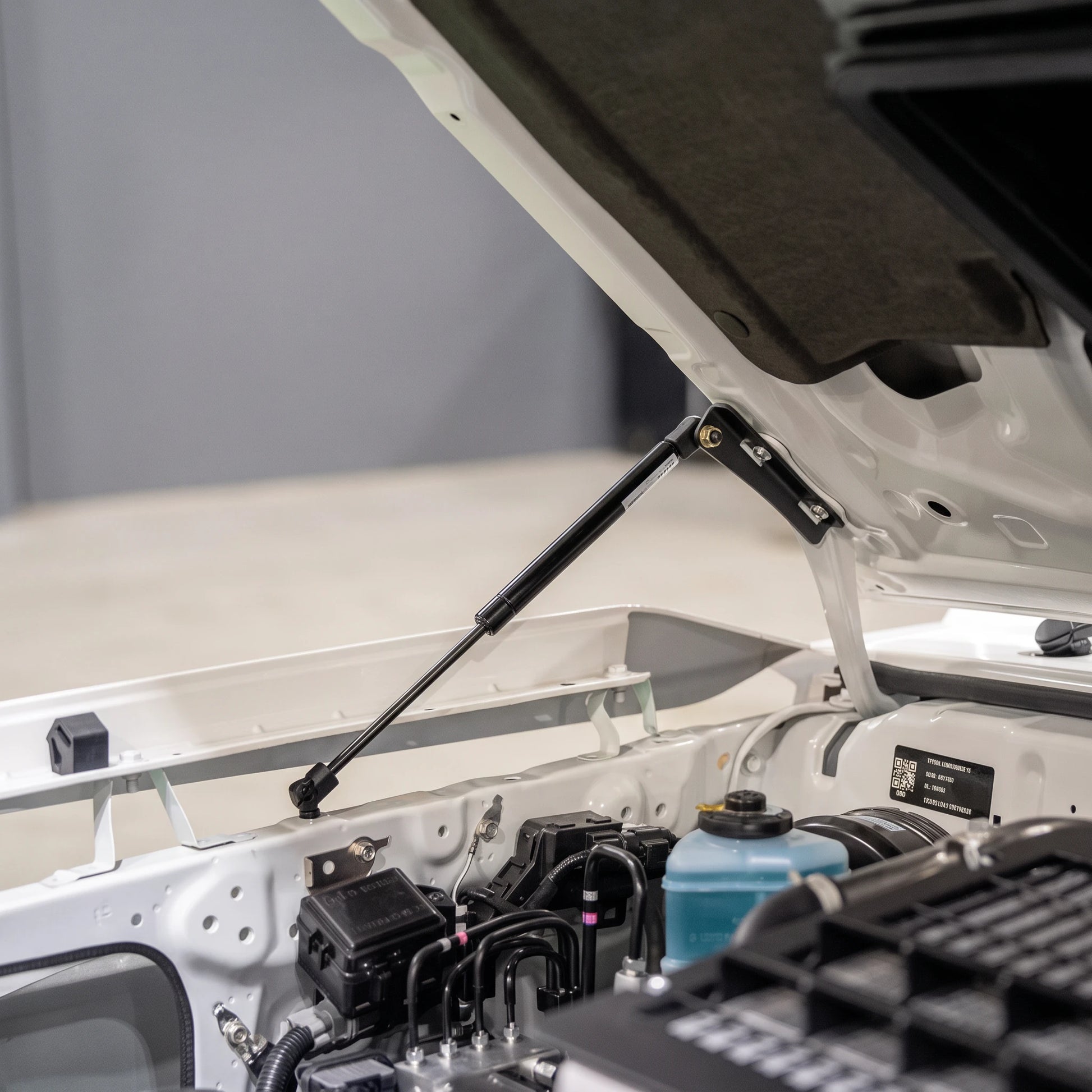 70 Series Land Cruiser bonnet held open by the fitted gas strut kit, viewed from the engine bay